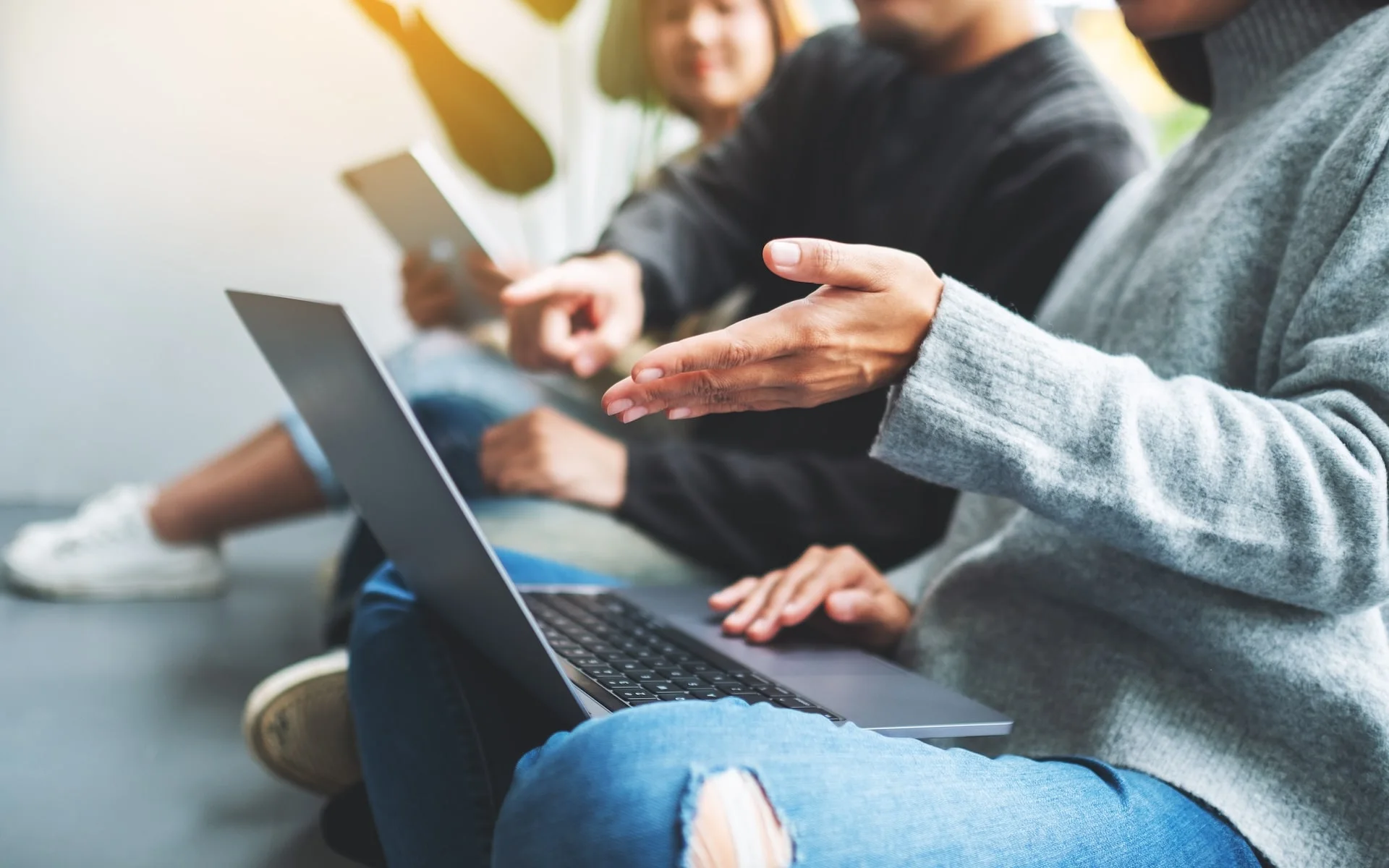 Colleagues discussing their work beside a laptop